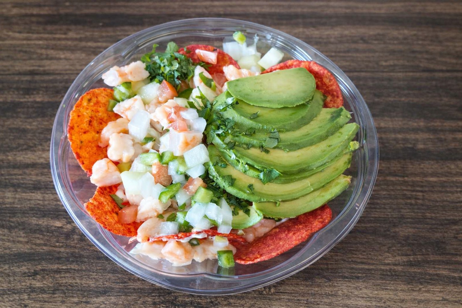 Signature Tosti Ceviche: citrus-marinated shrimp with pico de gallo and sliced avocado over red tostada chips